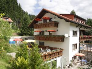 a building with a balcony with red umbrellas on it at Haus Bernhardt-Fromm in St. Blasien