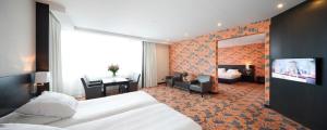 a hotel room with a bed and a desk and a television at Hotel Duiven bij Arnhem A12 in Duiven