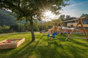 um playground em um campo com o sol atrás de uma árvore em Gasthof-Pension Silvia em Haibach ob der Donau