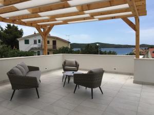 a patio with chairs and a table on a roof at Apartments Plavi&Žuti in Zaboric