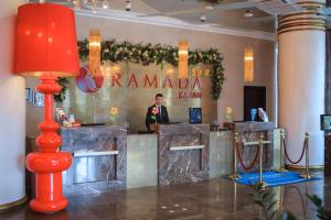 a man standing at a bar in a hotel lobby at Ramada by Wyndham Kazan City Centre in Kazan