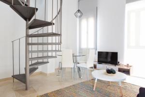 a living room with a spiral staircase and a table and chairs at Suncity Flat Gigantes in Málaga