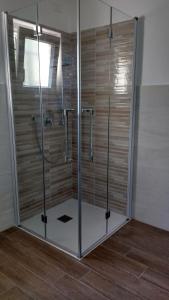 - une douche avec des portes en verre dans la chambre dans l'établissement La vie est belle, à Finale Ligure