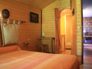 a bedroom with a bed and a wooden wall at Les Pascals in Saint-Paul-lès-Romans