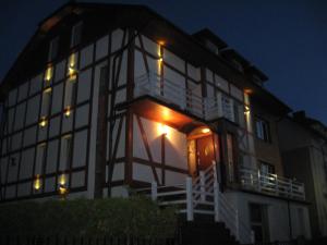 a large building with an open door at night at Oceania Mielno in Mielno