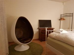 a room with a large chair in the corner of a bedroom at Basel Charme Apartments in Basel
