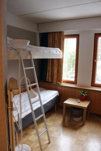 Aapiskukko Hotel في Pälkäne: غرفة مع سرير بطابقين وسلم