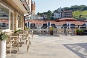 eine Reihe von Stühlen und Tischen auf einer Terrasse in der Unterkunft Hotel Flysch in Zumaia