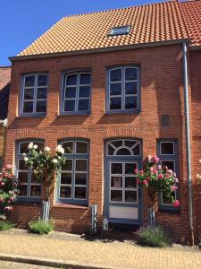 una casa in mattoni con finestre e fiori di fronte di "Auszeit Friedrichstadt" a Friedrichstadt