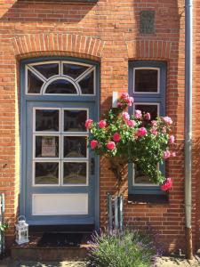 una casa in mattoni con porta blu e fiori di "Auszeit Friedrichstadt" a Friedrichstadt