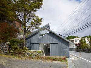 un edificio azul con una ventana en el lateral de una calle en Koyasan Guesthouse Kokuu en Koyasan