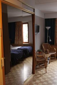 een kamer met een slaapkamer met een bed en een spiegel bij Aapiskukko Hotel in Pälkäne