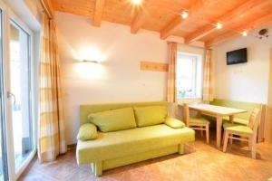 a living room with a green couch and a table at Apart Muntane in Ischgl