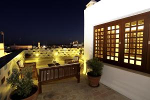 balkon z ławkami i widokiem na miasto w nocy w obiekcie Hostal El Alojado de Velarde w mieście Conil de la Frontera +28 zdjęć