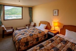 una camera d'albergo con due letti e una finestra di Okido Hotel a Tonosho
