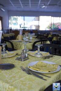 a table with plates and napkins on top of it at Hotel Mimosa in Spotorno