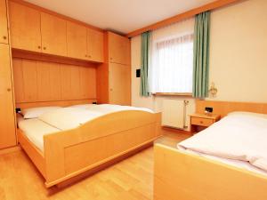 a bedroom with two beds and a window at Ciasa Parom in San Cassiano