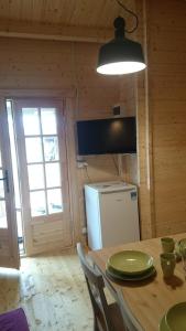 a kitchen with a table and a refrigerator at Domki Przy Orzechu in Lubin