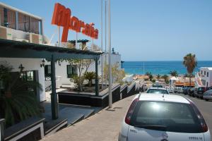 een auto geparkeerd voor een hotel in een straat bij Apartamentos Moraña in Puerto del Carmen