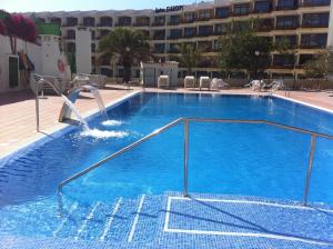 une grande piscine bleue avec un toboggan dans l'établissement Apartamentos Australia, à Playa del Ingles