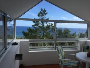a view of the ocean from a room with windows at Populo Beach Attic in Ponta Delgada