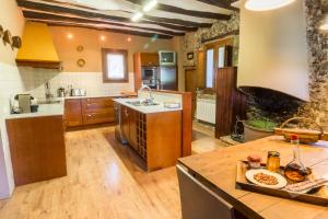 a large kitchen with wooden floors and wooden cabinets at La Masia del Batlle in Sarroqueta