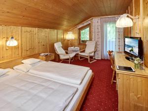 1 dormitorio con 1 cama y TV en una habitación en Hotel Monika, en Gaschurn