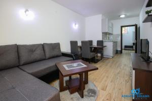 ein Wohnzimmer mit einem Sofa und einem Tisch in der Unterkunft Adriatic Dreams Apartments in Dobra Voda