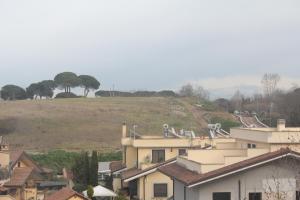 a town with houses and a hill in the background at Residence Antica Via Ostiense. in Acilia