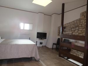 a bedroom with a bed and a flat screen tv at Antiche Mura Apartments "Nel Cuore della Puglia"bivani, cucina, terrazzo in Turi