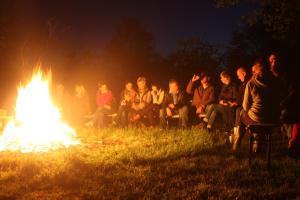 Eine Gruppe von Menschen, die um ein Feuer herum sitzen in der Unterkunft Forsthof Niendorf in Teterow