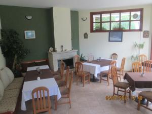a restaurant with tables and chairs and a fireplace at Fisherman's Hut Family Hotel in Beden