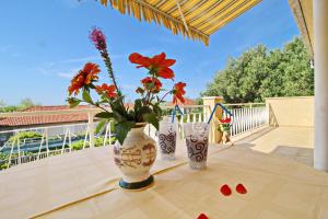 two vases with flowers on a table on a balcony at Apartment Pehar in Orebić