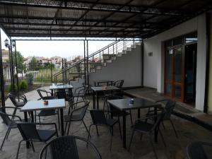 eine Terrasse mit Tischen und Stühlen und eine Treppe in der Unterkunft Altay Guest House in Lozenets