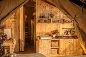 a kitchen with wooden walls and a counter with a sink at Camping Costa Ponente in Cefalù