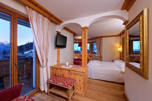 a bedroom with a bed and a mirror at Boutique Hotel Diana in Madonna di Campiglio
