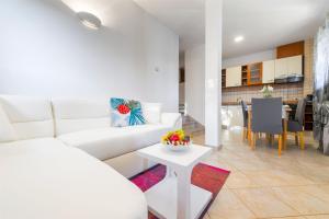 een woonkamer met een witte bank en een tafel bij Villa Boulder in Okrug Donji