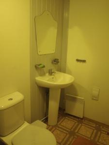 a bathroom with a white sink and a toilet at Camping House Aivari in Inčukalns