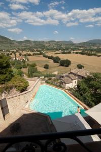 a large swimming pool with a person standing in front of it at La Bastiglia in Spello