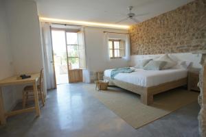 a bedroom with a bed and a desk and a window at Ca Na Nina in Sant Llorenç des Cardassar