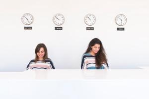 two girls standing behind a table with clocks at Apartaments Els Llorers in Lloret de Mar