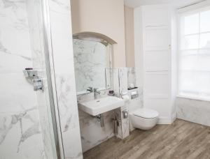 a bathroom with a toilet, sink, and mirror at Arden House - Eden Hotel Collection in Stratford-upon-Avon