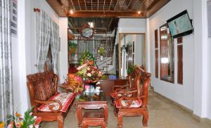a living room with chairs and a table and a clock at Ngoc Tung Mini Hotel in Hue