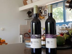 two bottles of wine sitting on top of a counter at Nano's Place in Ma‘yan Barukh