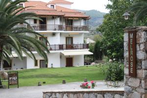 una gran casa blanca con una palmera delante de ella en Melrose, en Skopelos Town