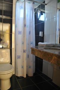 a bathroom with a toilet and a shower curtain at Benna Hotel in Antalya