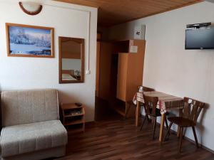 ein Wohnzimmer mit einem Tisch, Stühlen und einem Sofa in der Unterkunft House Jole in Drežnik Grad
