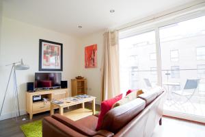 sala de estar con sofá y ventana grande en Signet Apartments - Ceres, en Cambridge