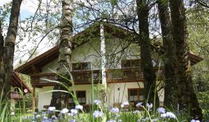 una casa en el bosque con flores delante en Ferienhäuser "In der Waldperle", en Bischofsmais
