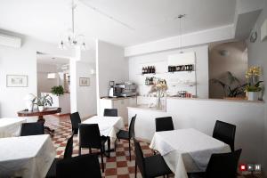 a restaurant with white tables and chairs and a kitchen at Albergo Giugni in Prato